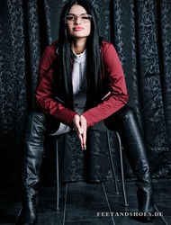 Dunkelhaariges Model in rotem Blazer und schwarzen Overknee-Lederstiefeln &ndash; FeetandShoes.de